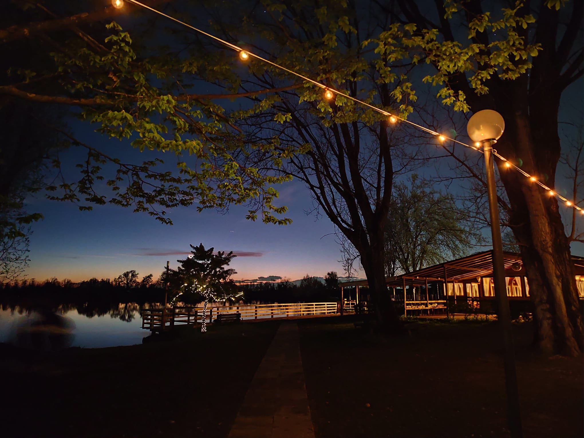 Il giardino sul lago di sera, con le luci accese